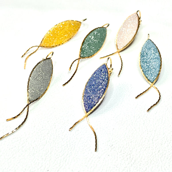 Boucles d'oreilles Nune modèle Nayati en forme de fins poissons dans 6 coloris de cuirs pailletés, cerclés de chaîne dorée, vues de dessus, sur fond blanc