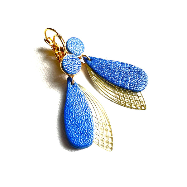 Boucles d'oreilles dorées Nune modèle Pétales en cuir bleu pervenche nacré sur fond blanc