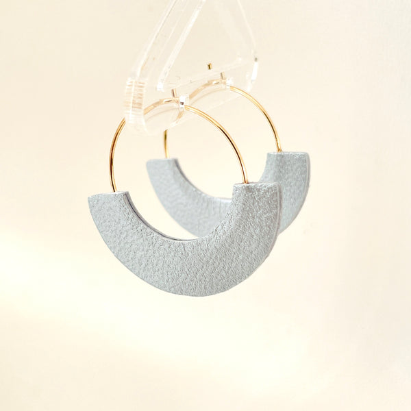 Boucles créoles Nune modèle Mezzaluna dorées en forme de demi-lunes en cuir recyclé gris métallisé