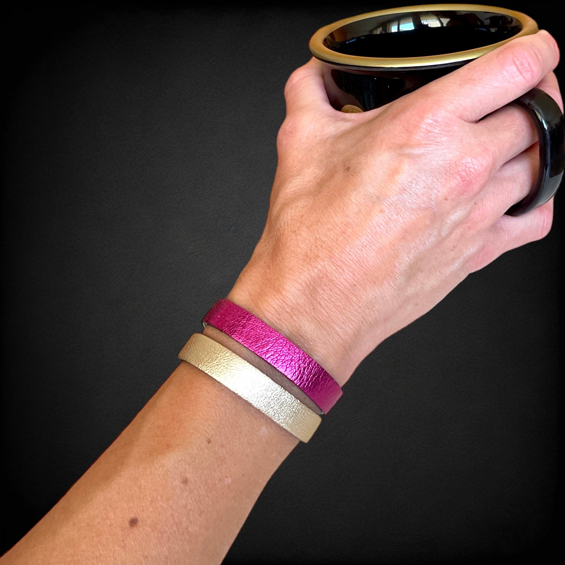 2 bracelets en cuir double face bicolores, avec fermoir boucle dorée en T, en cuirs fushia métallisé pour le 1er, et doré antique mat pour le second, portés au poignet