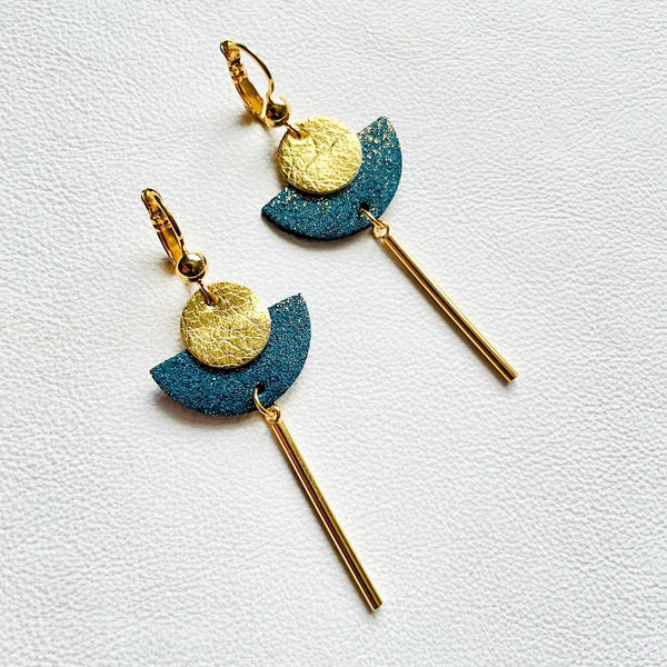 Longues boucles d'oreilles dorées en forme de demi-lune en cuirs doré et vert canard pailleté or recyclé, sur fond blanc. Modèle Cyclaé de Nune