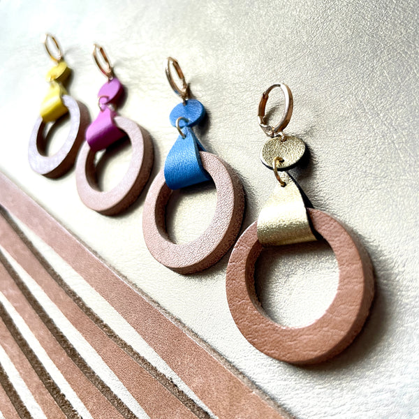 boucles d'oreilles dorées Nune modèle Cyllène en cuirs beige amande et doré satiné, bleu denim mat, mauve mat, jaune citron sur fond gris doré