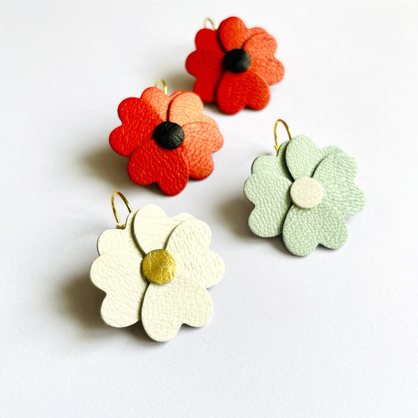 Boucles d'oreilles Nune en forme de petites fleurs , modèle Lalie, en cuirs  coquelicot nacré & noir, blanc cassé nacré & doré, bleu lune nacré & blanc cassé nacré, sur fond blanc
