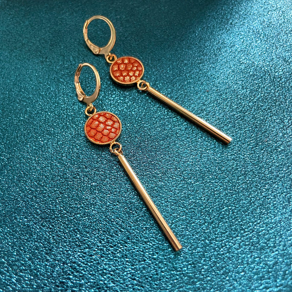 Nune longues et fines boucles d'oreilles dorées Nida avec serti en cuir orangé or façon serpent, sur fond cuir saphir pailelté